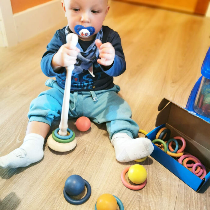 A kid playing with Tickit Wooden rings and base - Discovery Playtime