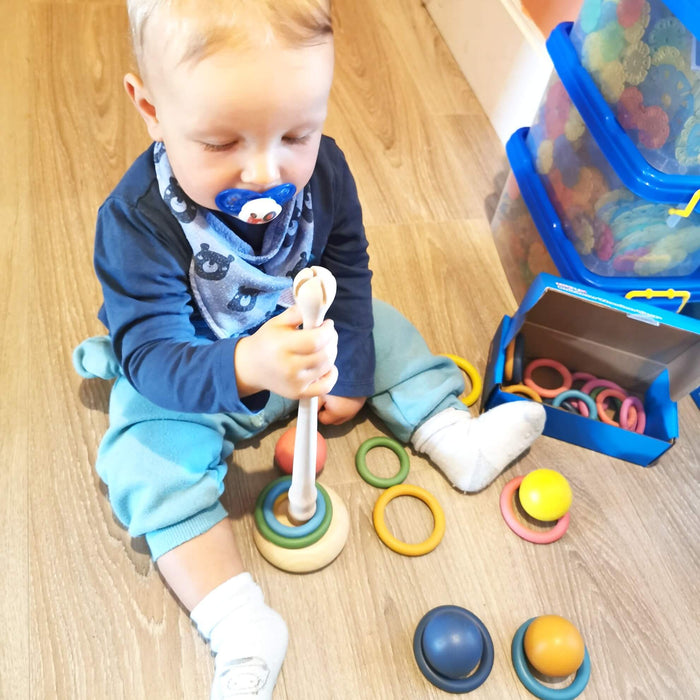 A child playing with Tickit Wooden rings and base by Discovery Playtime